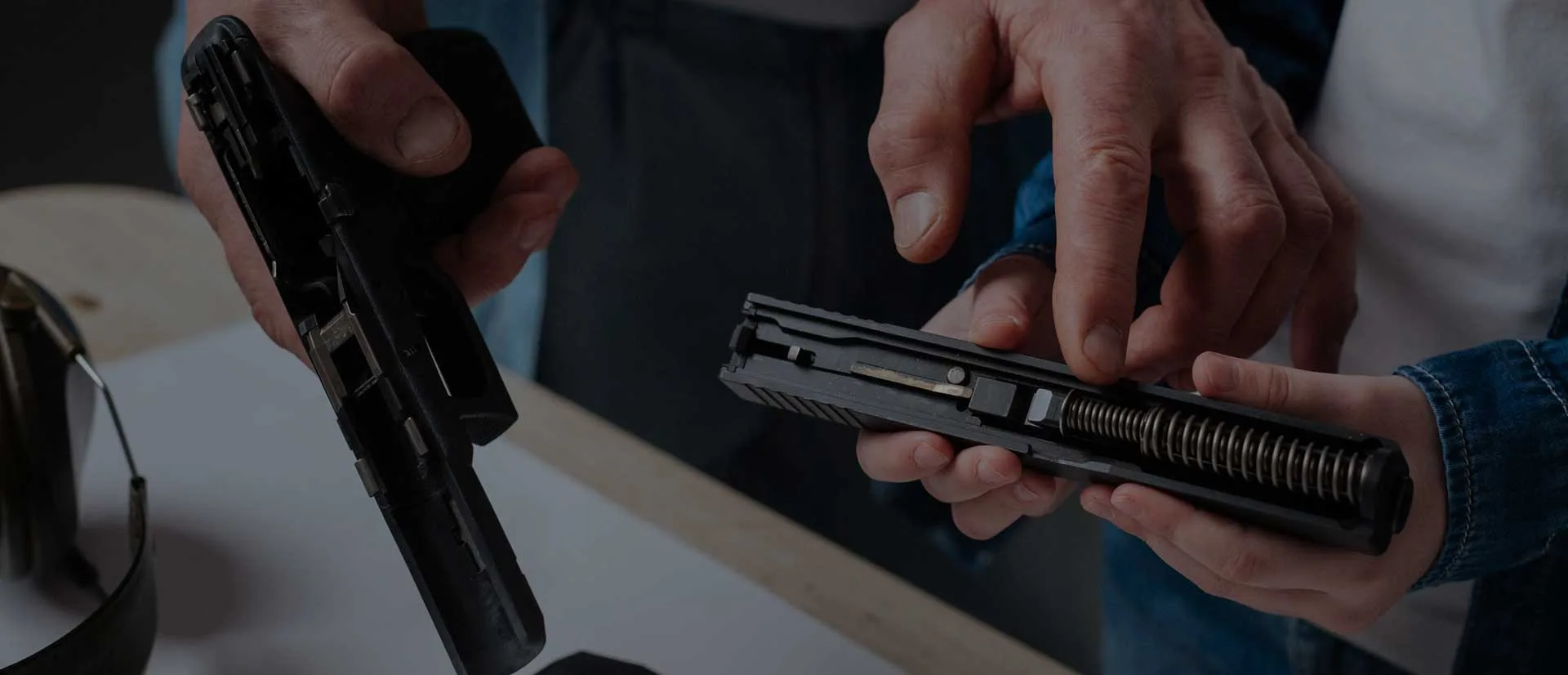 Instructor demonstrating pistol disassembly and maintenance to a student during firearms training in Westchester County, NY